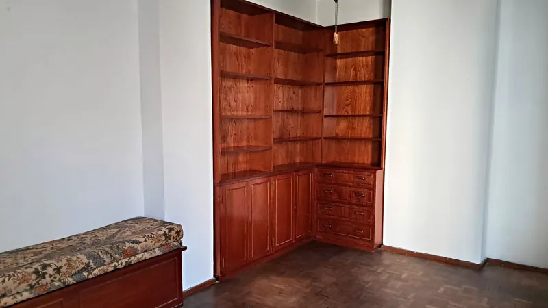 Rincón con biblioteca de madera y paredes blancas