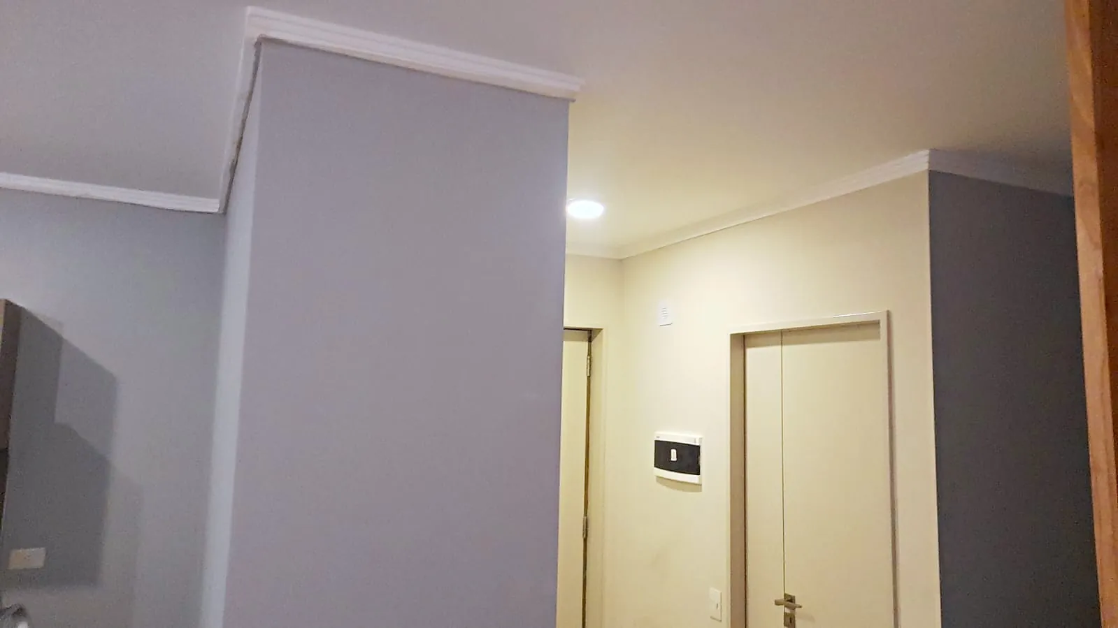Columna pintada en gris con molduras blancas y paredes crema